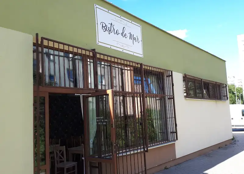 Wejście do Bistro de Mar: szyld nad drzwiami i kuta krata