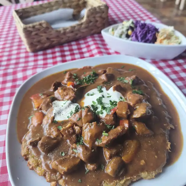 Placek ziemniaczany pod gulaszem ze śmietaną