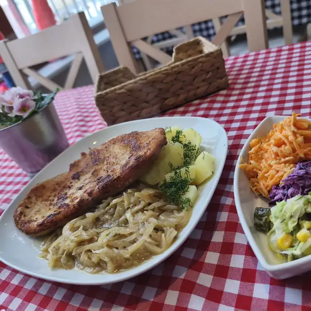 Kotlet z zasmażaną kapustą i ziemniakami, obok trzy surówki
